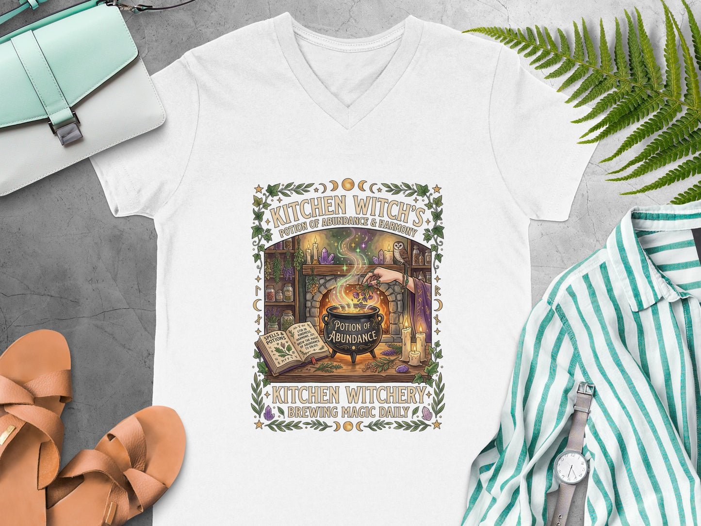 White v-neck t-shirt with "Kitchen Witchery" graphic featuring potions and cauldron.