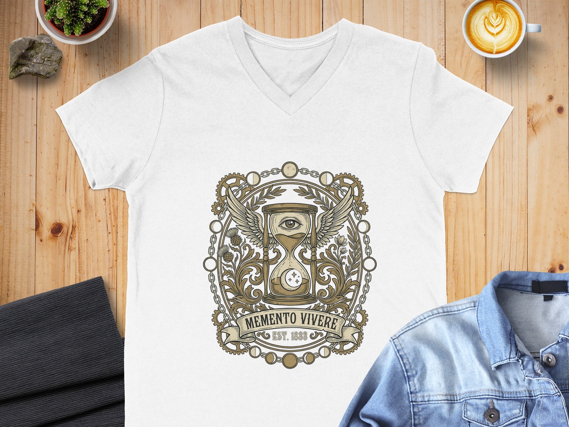 White v-neck t-shirt with ornate hourglass, wings, and "Memento Vivere Est. 1888" design.