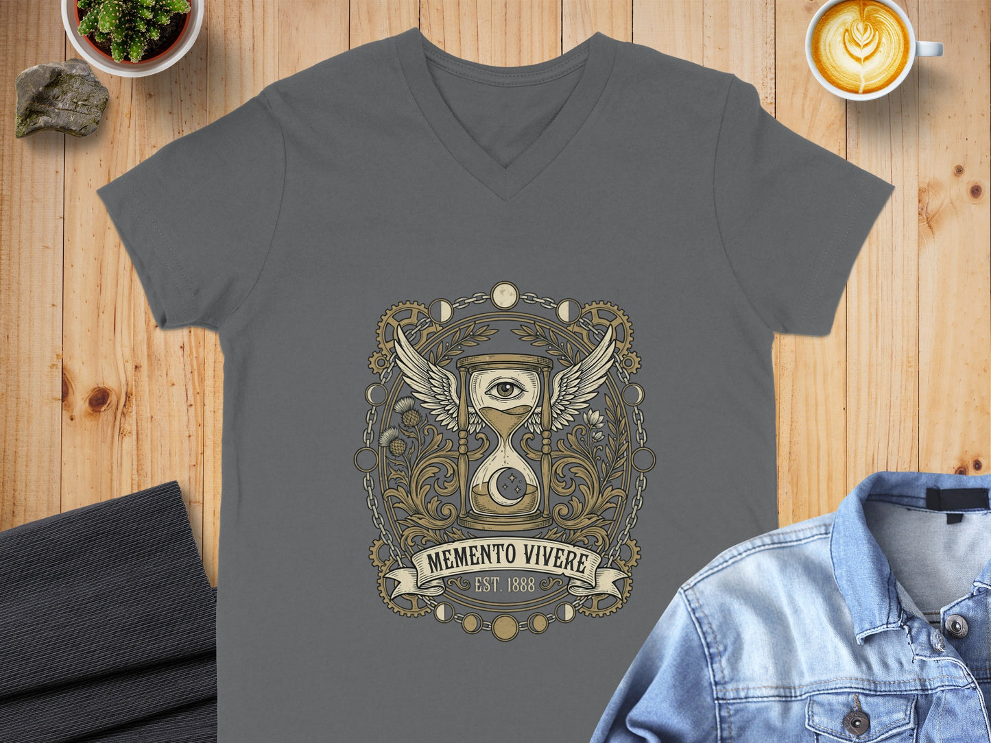 Grey v-neck t-shirt featuring a clockwork winged eye emblem with "Memento Vivere" text.