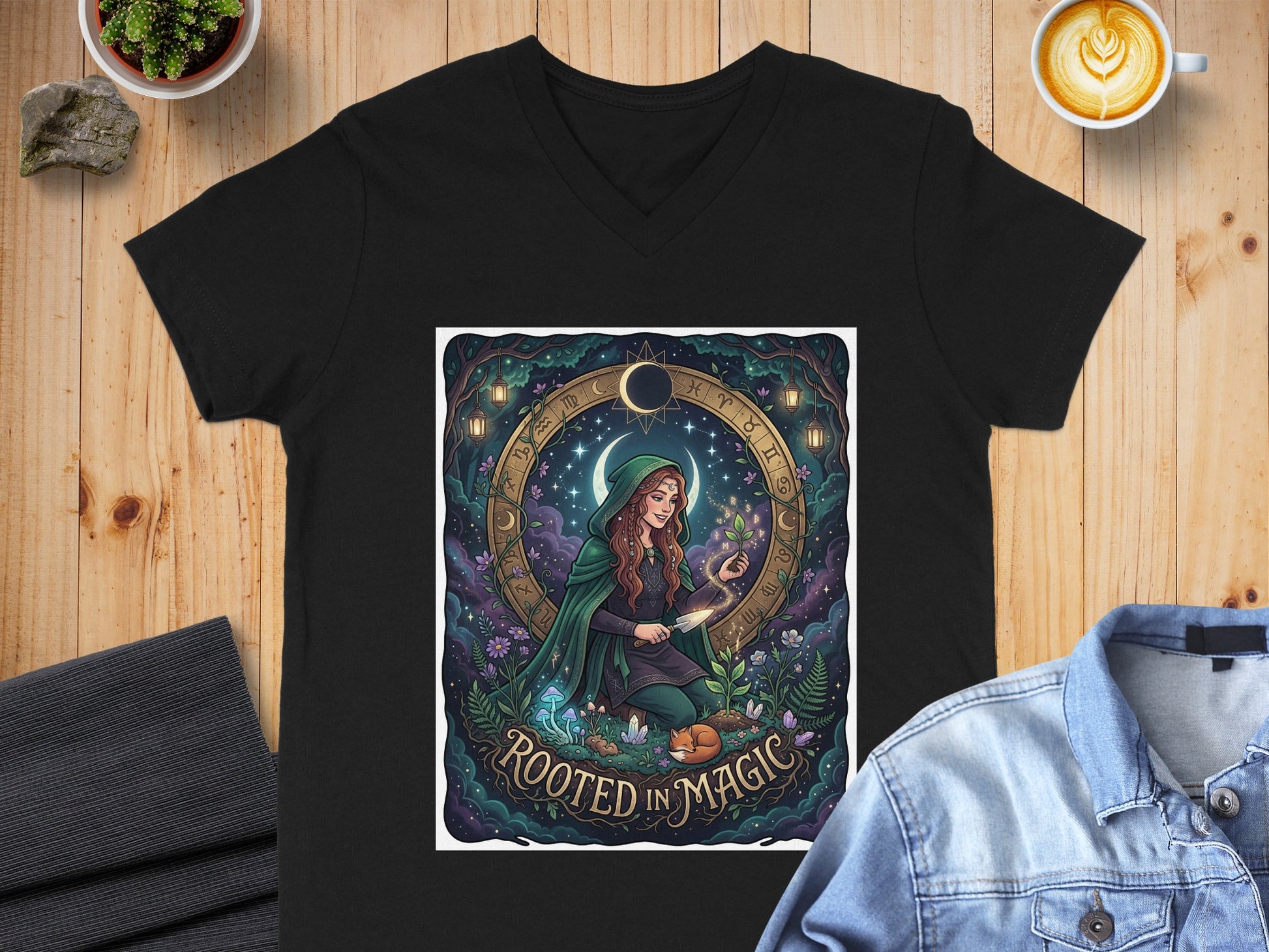 Black v-neck t-shirt with circular graphic of a woman in a green cloak with celestial and floral elements.
