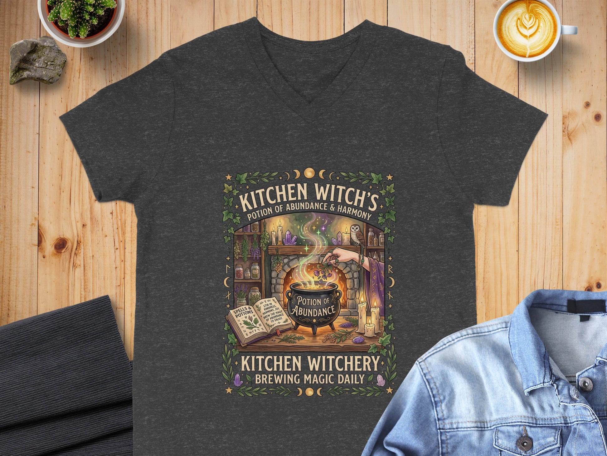 Dark gray t-shirt with "Kitchen Witchery Brewing Magic Daily" text and potion graphic.