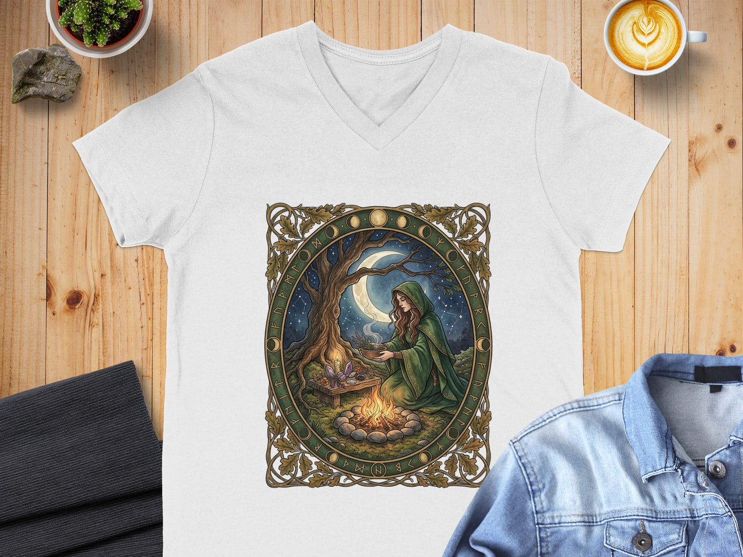White v-neck t-shirt with Celtic knot border and woman by campfire under moonlit sky.
