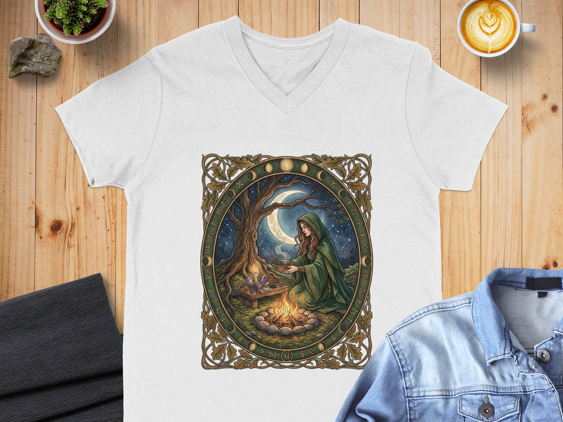 White v-neck t-shirt with mystical moon and campfire graphic.